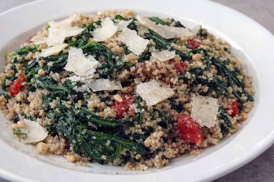 Heerlijk en gezond: bord met roergebakte quinoa en spinazie. Bekijk het recept!