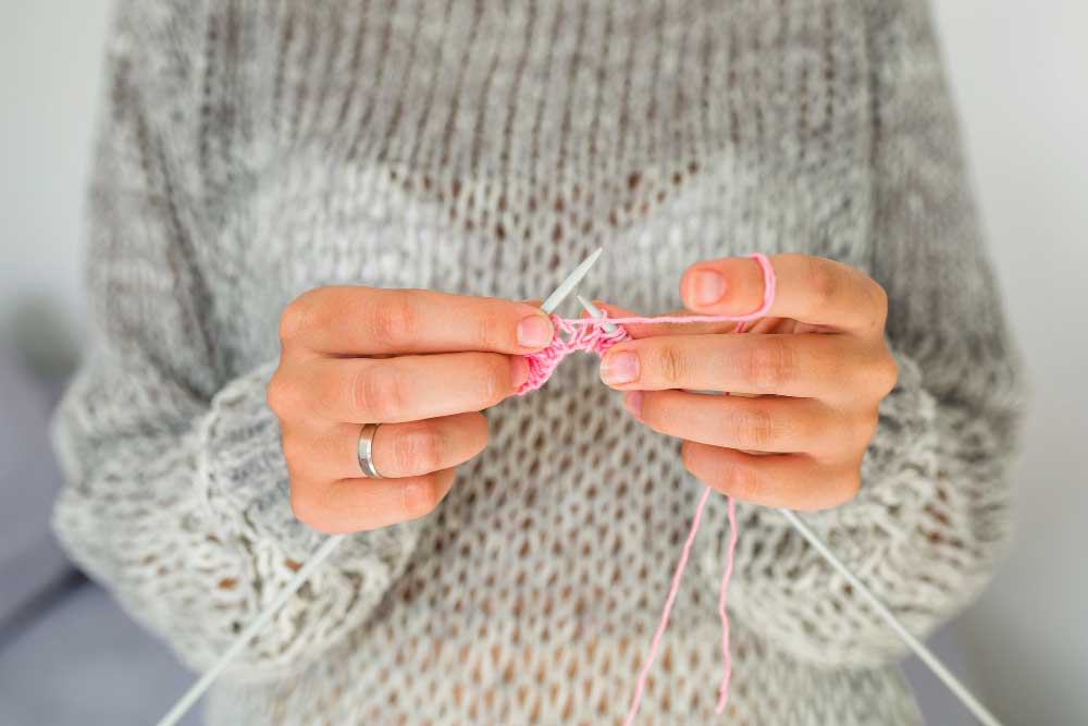 Vrouw aan het breien: een van de 9 tips voor minder stress is doen wat je leuk vindt!