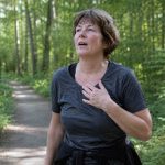 Benauwd, maar de arts vindt niets: dit kan er spelen Vrouw in bos die zich benauwd voelt, terwijl ze weet dat er geen oorzaak is gevonden.